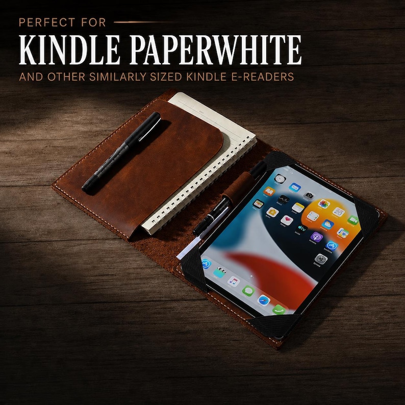 K&ouml;nnte beinhalten: Eine braune Lederh&uuml;lle mit einem Notizblock und einem schwarzen Stift auf der linken Seite sowie einem Tablet, das mit schwarzen Eckb&auml;ndern auf der rechten Seite befestigt ist. Der Text lautet: PERFECT FOR KINDLE PAPERWHITE AND OTHER SIMILARLY SIZED KINDLE E-READERS.