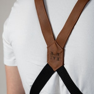 May include: Brown leather suspenders with black straps and a personalized leather patch that says "MICHAEL" in a black font.
