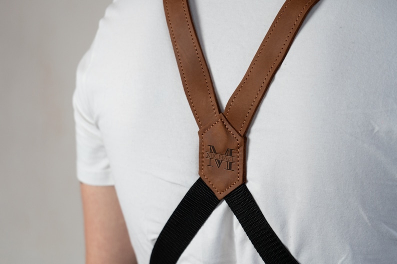 May include: Brown leather suspenders with black straps and a personalized leather patch that says "MICHAEL" in a black font.