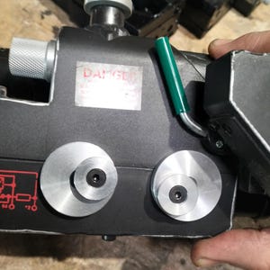 Könnte beinhalten: Ein schwarzes Requisit mit silbernen Zifferblättern und einem grünen Griff. Das Gerät hat einen Aufkleber mit der Aufschrift "DANGER". Die Requisite ist wahrscheinlich eine Nachbildung eines Geräts aus einem Science-Fiction-Film.