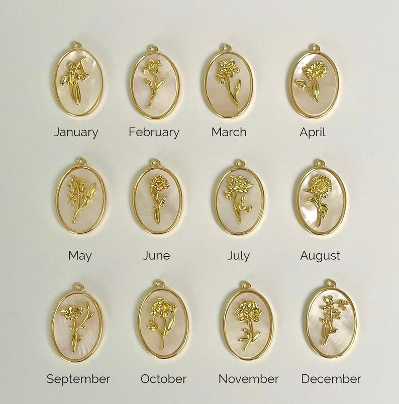 May include: Twelve oval pendants featuring gold-toned metal flower reliefs set against a white mother-of-pearl background. Each pendant is labeled with a month from January to December, representing birth flowers in a grid arrangement.