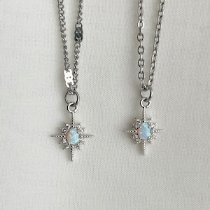 May include: Two silver necklaces with opal starburst pendants. The necklaces have different chain styles.