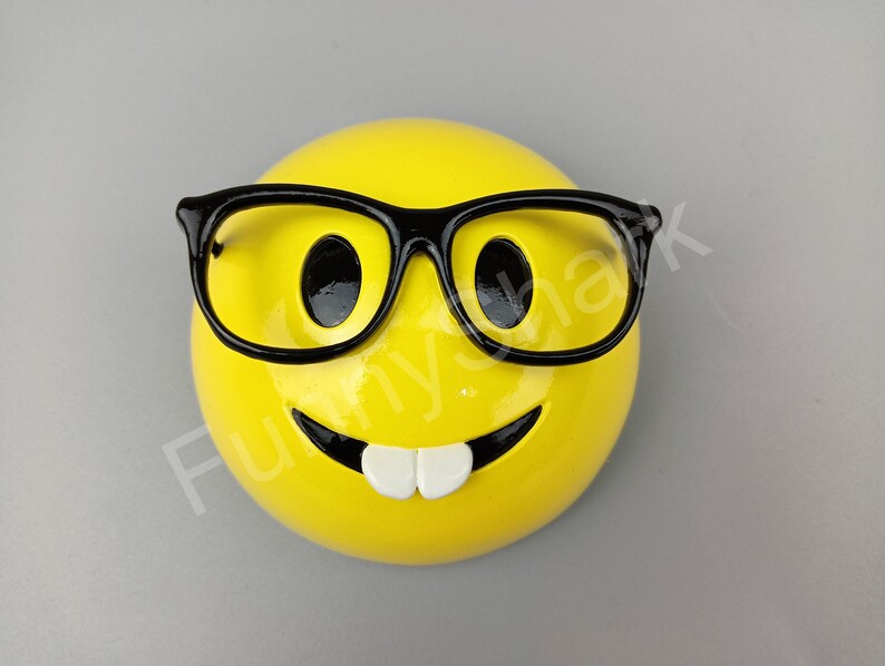 Puede incluir: Cara sonriente amarilla con gafas de montura negra y una amplia sonrisa.