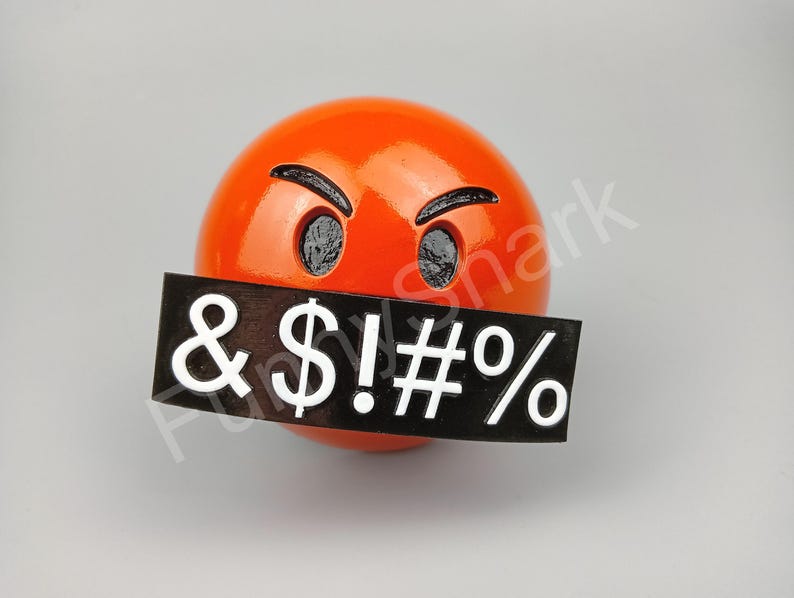 May include: A bright orange sphere with black eyes and eyebrows, and a black rectangle covering the mouth. The rectangle displays the symbols & $ ! # % in white. The design is a humorous, expressive representation.