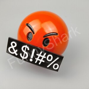 May include: A bright orange emoji with angry eyes and eyebrows, and a black sign with white symbols: & $ ! # %.