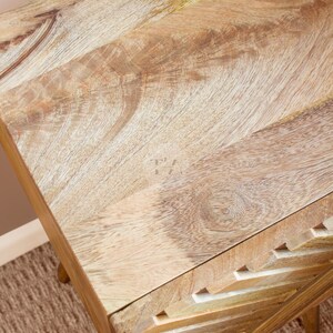 May include: A wooden side table with a unique geometric design on the front. The top of the table is made of light wood with a natural grain pattern.