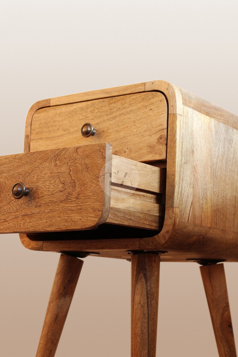 May include: A wooden bedside table with two drawers and rounded edges. The top drawer is open, revealing a second drawer inside. The bedside table has four short, tapered legs.