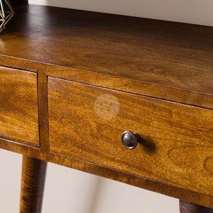 May include: A wooden side table with two drawers and a shelf. The table has a dark brown finish and rounded edges. The drawers have metal knobs.