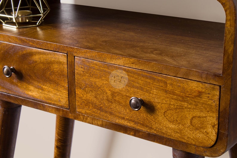 May include: A wooden side table with two drawers and a shelf. The table has a dark brown finish and rounded edges. The drawers have metal knobs.