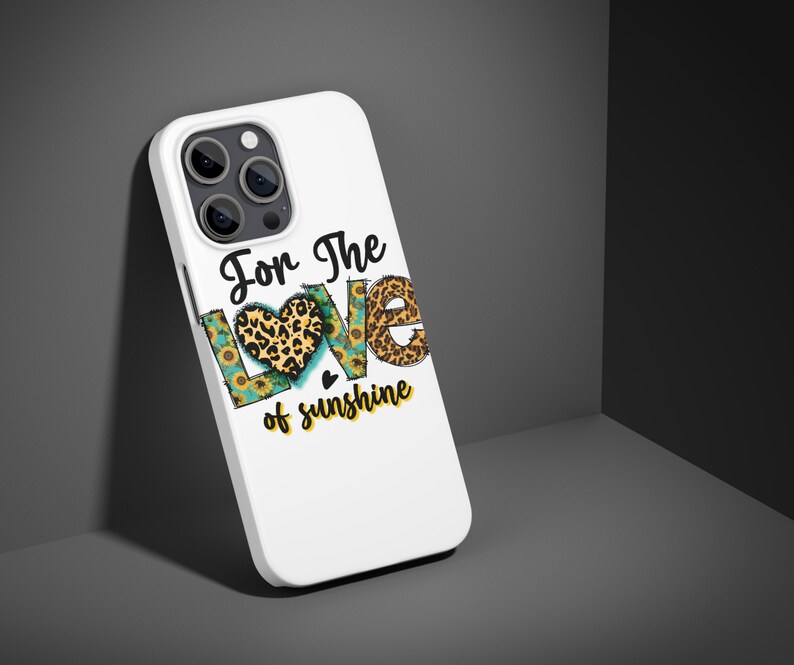 Puede incluir: Carcasa blanca para iPhone con un gr&aacute;fico de un coraz&oacute;n con estampado de leopardo y girasoles. El texto "For the love of sunshine" est&aacute; impreso en la carcasa.
