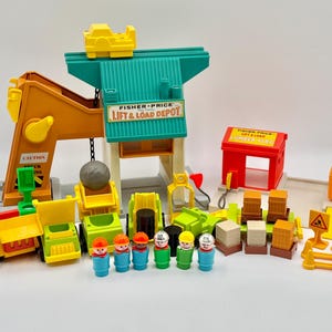 May include: A Fisher-Price Lift & Load Depot playset featuring a large orange crane, a teal building, a red lumber yard structure, various yellow and green construction vehicles, small plastic figures, brown crates, and yellow road signs.