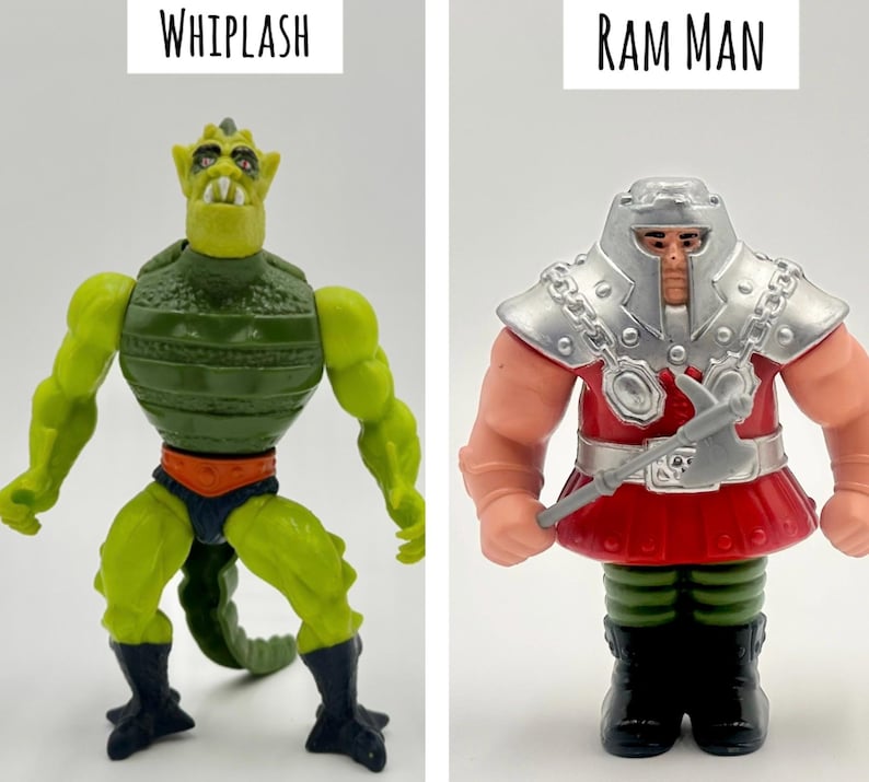 May include: Two action figures, "Whiplash" and "Ram Man", are displayed. Whiplash is green and yellow with a reptilian design, and the text "WHIPLASH" is above it. Ram Man is red, silver, and tan, with the text "RAM MAN" above it.