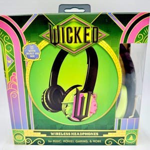 May include: A box featuring "WICKED" wireless headphones. The box is green, black, and pink, with the headphones displayed prominently. The headphones are black with a green and pink graphic. Text on the box reads "WIRELESS HEADPHONES for MUSIC, MOVIES, GAMING, & MORE."