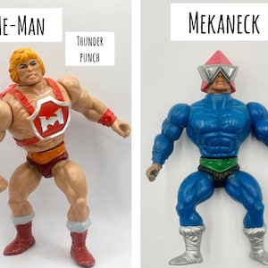 May include: Two action figures from the He-Man and the Masters of the Universe toy line. The figure on the left is He-Man, with blonde hair, a red harness, and red boots. The figure on the right is Mekaneck, with a blue body and a red helmet.