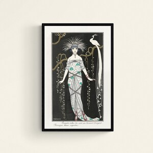May include: Art Deco print featuring a woman in an elaborate gown with a peacock. The illustration is in black, white, and teal, with gold accents. The text at the bottom reads "Grande robe de soir en brocart d'argent. Perruque bleue, aigrettes."