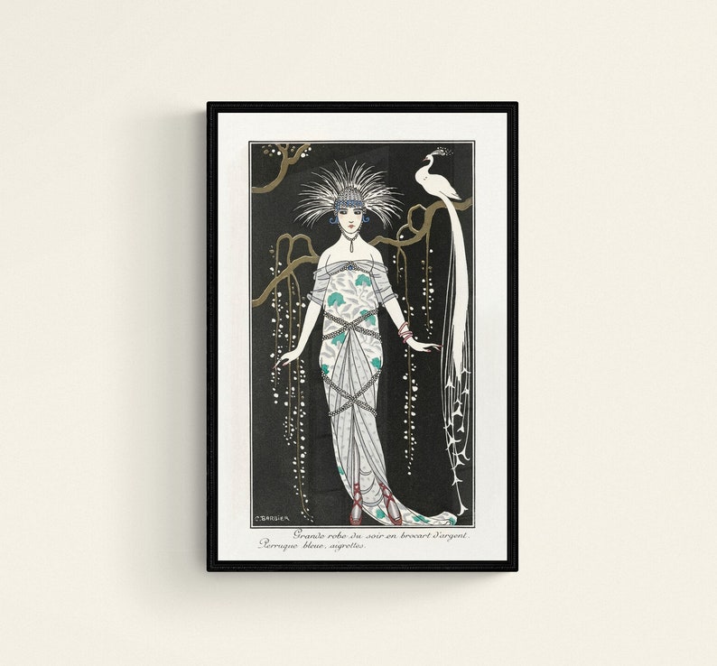 May include: Art Deco print featuring a woman in an elaborate gown with a peacock. The illustration is in black, white, and teal, with gold accents. The text at the bottom reads "Grande robe de soir en brocart d'argent. Perruque bleue, aigrettes."