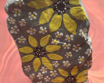 Flores de margaritas grises, blancas y amarillas pintadas en roca, arte en piedra