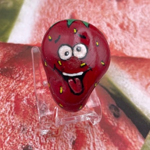 Fresa de cara tonta de caricatura caprichosa, roca pintada de verano, arte de pintura de piedra