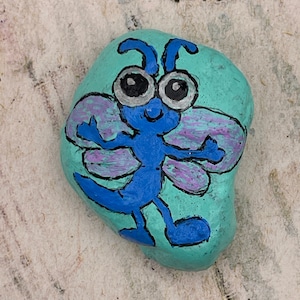Libélula de dibujos animados caprichosos, arte animal, roca pintada, pintura en piedra