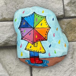 Cute Rainy Day Child Wearing Raincoat and Holding Rainbow Umbrella in the Spring Rain, Unique Painted Rock, Stone Art