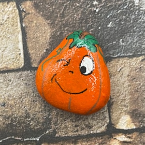 Grillige oranje pompoen, handgeschilderde rots, herfstkunst, halloweenkunst, steenschildering