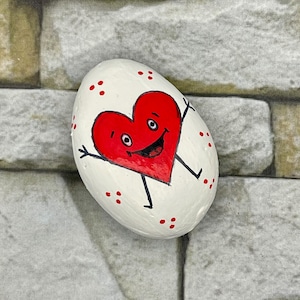 Corazón rojo sonriente caprichoso, abrazos, decoración de San Valentín, roca pintada, pintura de piedra