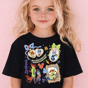 A young girl with blonde hair wearing a black t-shirt with colorful cartoon characters and designs.