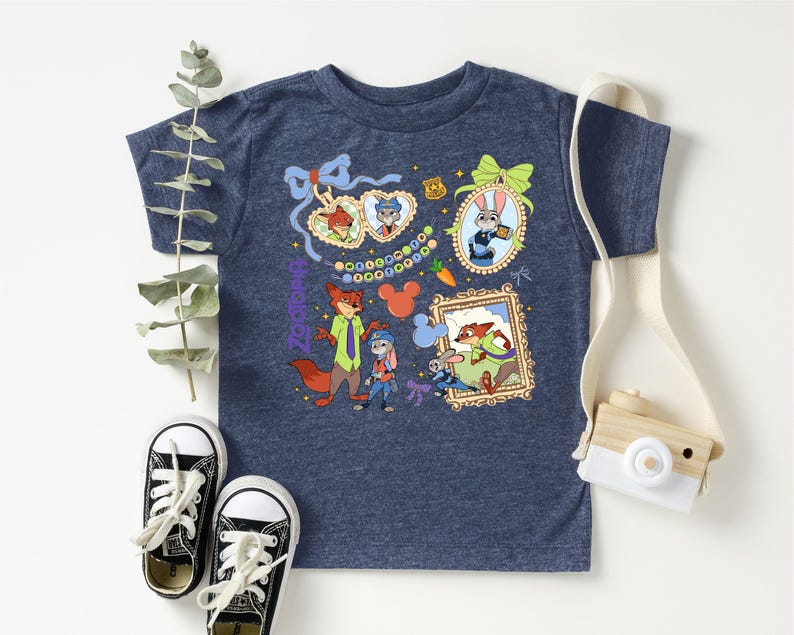 a blue t-shirt with a colorful graphic design, a pair of black and white sneakers, and a white camera.