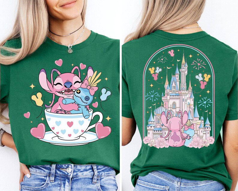 A green t-shirt with a cartoon image of two pink characters, one inside a teacup and the other on a castle, surrounded by hearts and fireworks.