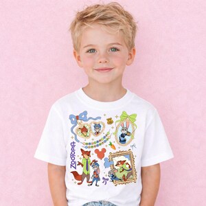 A young boy wearing a white t-shirt with various cartoon characters and designs printed on it, including a fox, rabbit, and other whimsical elements.