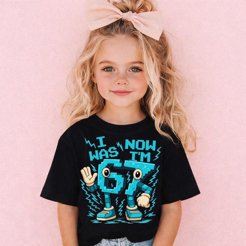 A young girl with blonde hair wearing a black t-shirt with a graphic design and text on it.