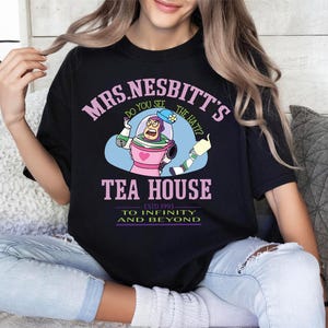 a woman sitting on a couch wearing a black t - shirt