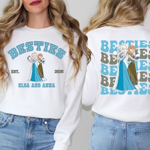 a woman wearing a white sweatshirt with the words besties, besties, and