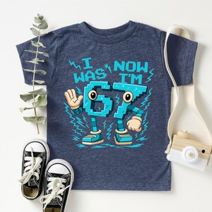 A blue t-shirt with a cartoon character design, a pair of black and white sneakers, and a camera.