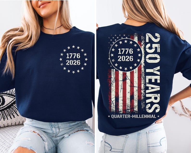A woman wearing a navy blue sweatshirt with a graphic design on the back. The design features a combination of stars and stripes, along with the text "1776", "2026", and "250 YEARS" printed on it.