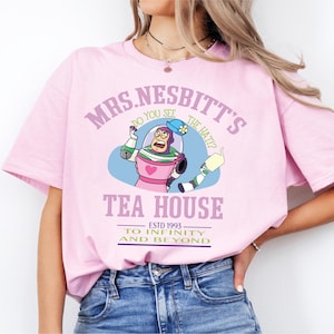 a woman wearing a pink shirt with a cartoon character on it