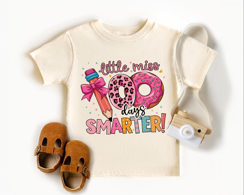 a white shirt with a pink donut and a pair of brown shoes