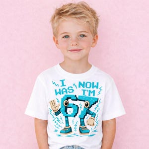 A young boy wearing a white t-shirt with a graphic design featuring a character in a blue and white color scheme.