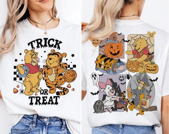 May include: White t-shirt with a Halloween graphic featuring Winnie the Pooh and Tigger. The front says "Trick or Treat" with the characters holding candy and pumpkins. The back shows more characters with pumpkins and Halloween elements.