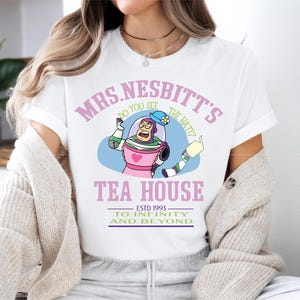 a woman sitting on a bed wearing a white shirt