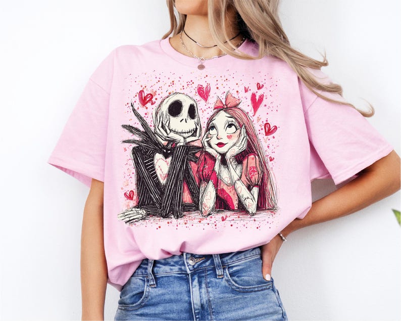 A woman wearing a pink t-shirt with a graphic design of a skeleton and a girl with a heart-shaped headband.