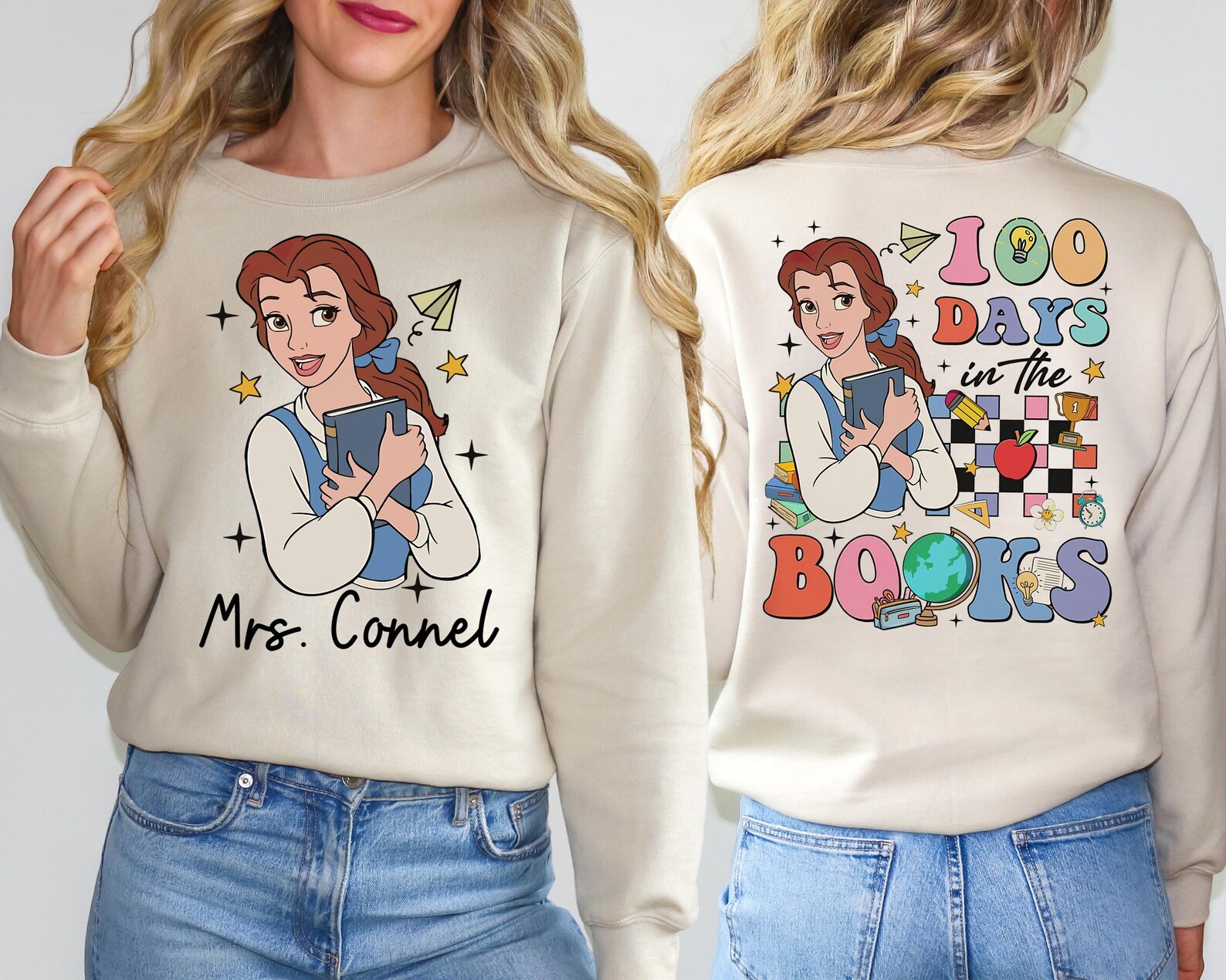 A light beige sweatshirt is modeled from both the front and back. The front features an illustration of a cartoon-style woman resembling Belle from Beauty and the Beast, holding a book with a paper airplane and stars around her. Below the image is the name “Mrs. Connel” in a black, handwritten-style font. The back of the sweatshirt showcases the same character, now part of a vibrant design with the words “100 DAYS in the BOOKS” in colorful, bold letters. The backdrop includes playful school-themed icons like a globe, apple, alarm clock, pencil, paper, books, stars, and a checkerboard pattern.