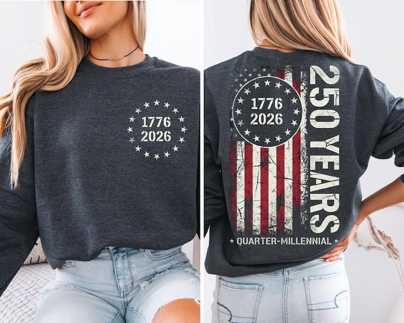 a woman wearing a grey sweatshirt with a graphic design on the back. The design includes a circle with the numbers 1776 and 2026, and an American flag pattern.