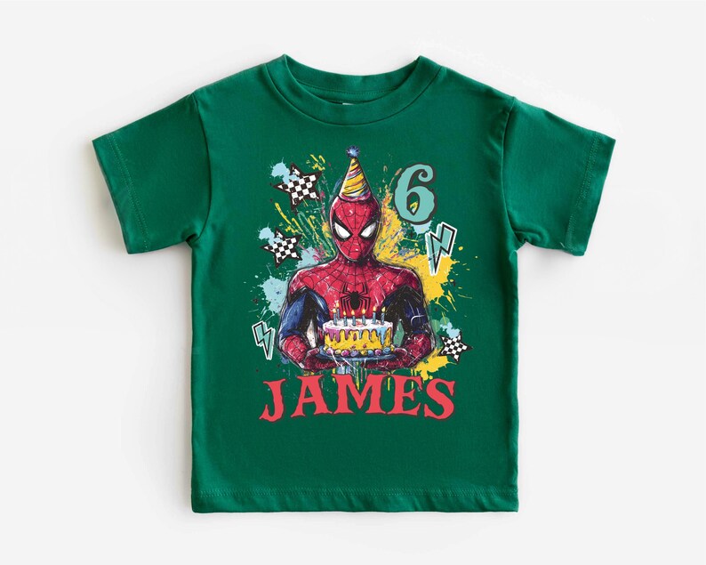 A green t-shirt with a Spider-Man graphic and the number 6, along with the text "JAMES" printed on it.