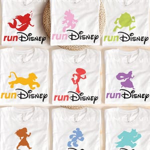 A collection of white t-shirts with various Disney-themed designs printed on them, including characters and logos.