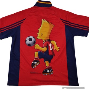 May include: Red and navy blue soccer jersey featuring Bart Simpson kicking a soccer ball. The jersey has a collar with yellow and red stripes and the number 10 on the back. The jersey is a vintage item.