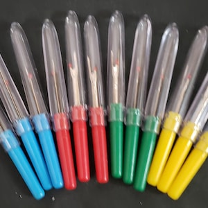 May include: A set of ten thread cutters with clear plastic handles and colored caps. The caps are red, blue, green, and yellow.