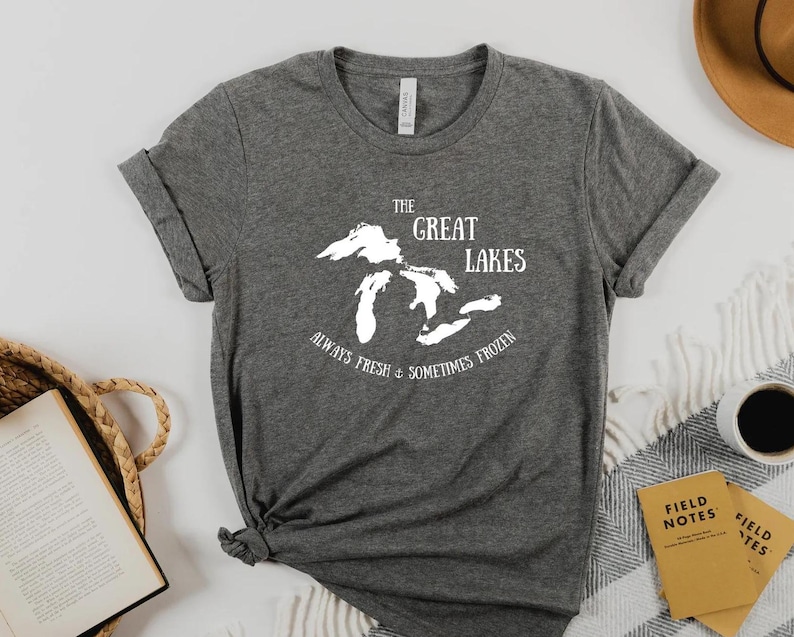 May include: A gray t-shirt with a white graphic of the Great Lakes and the text "The Great Lakes Always Fresh & Sometimes Frozen".