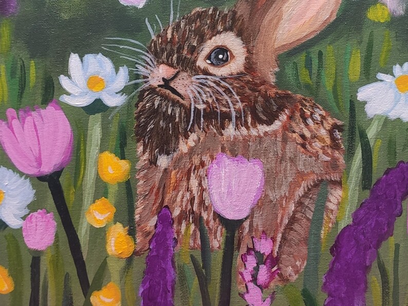 May include: An acrylic painting of a brown rabbit with textured fur standing in a field of colorful wildflowers. The scene features white daisies with yellow centers, pink tulips, purple spikes, and small yellow blossoms against a green background.