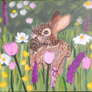 May include: An acrylic painting on canvas depicting a brown rabbit with long ears positioned in a vibrant meadow. The scene is filled with colorful wildflowers including white daisies, pink tulips, and tall purple spikes of lavender against green grass.